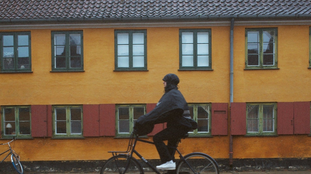 Cyclist wearing a rain poncho while riding a bicycle in the rain