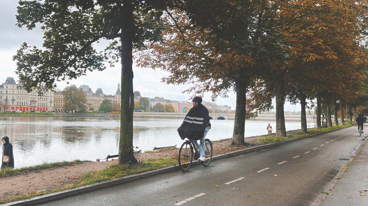 Cyclist commuting to work in the rain wearing waterproof cycling rainwear