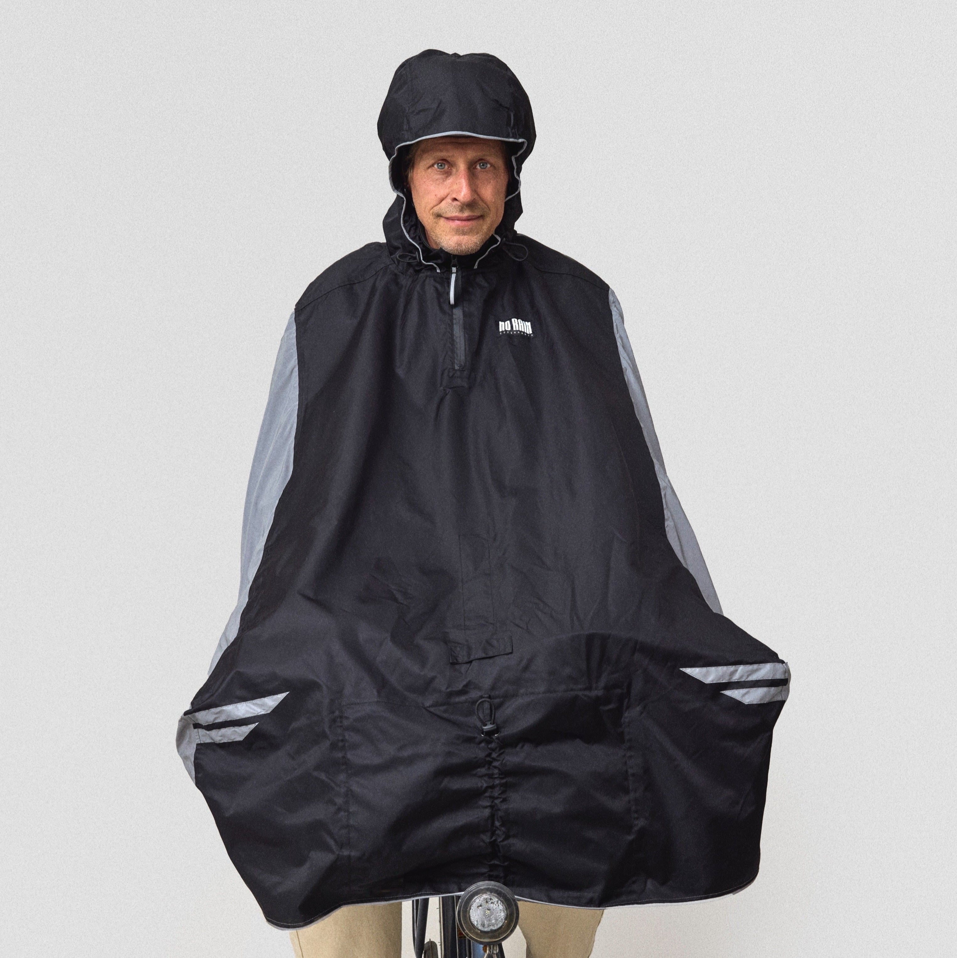 Person wearing a black NoRain bicycle poncho on a bicycle against a white background