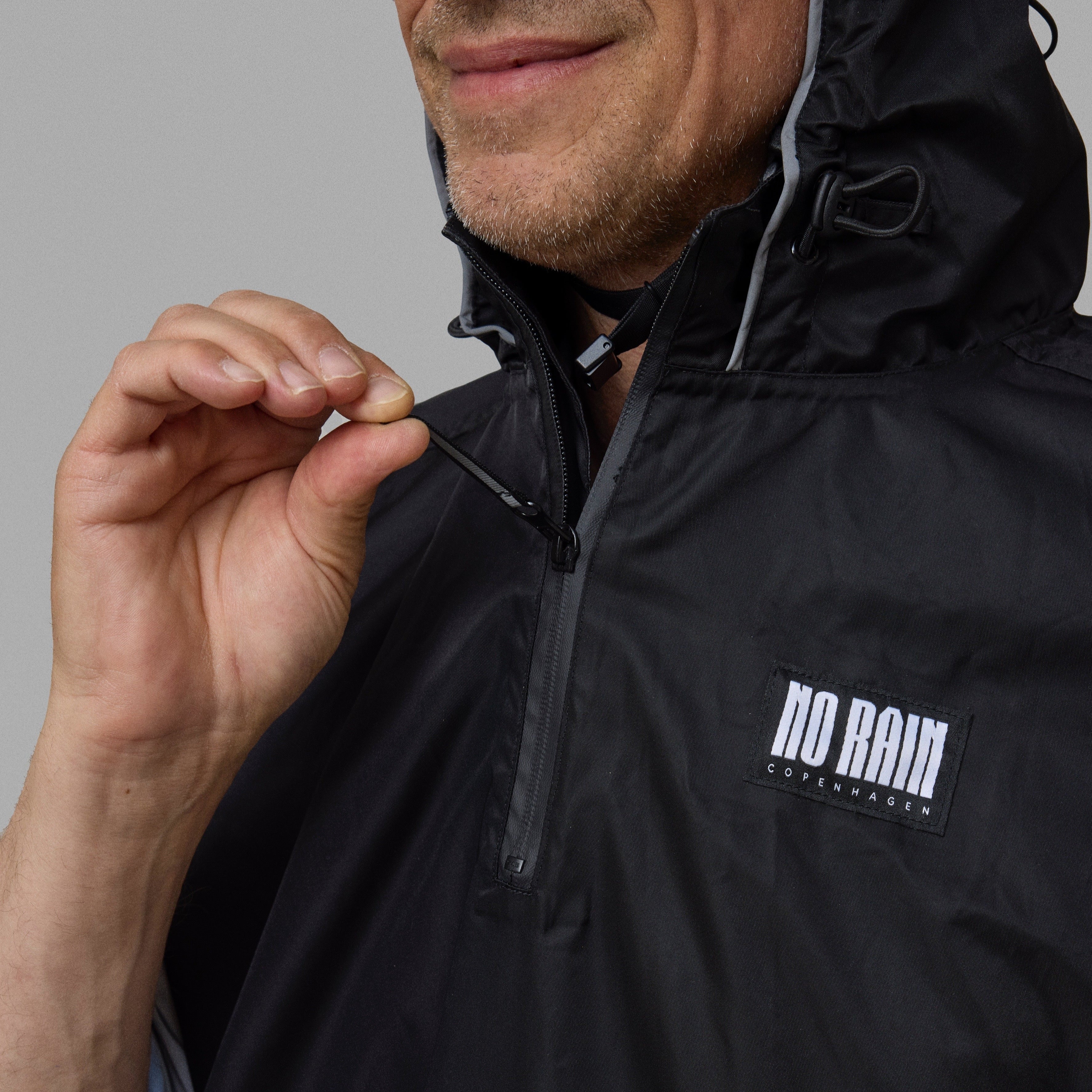 Person wearing a black NoRain bicycle with 'norain' logo on a gray background