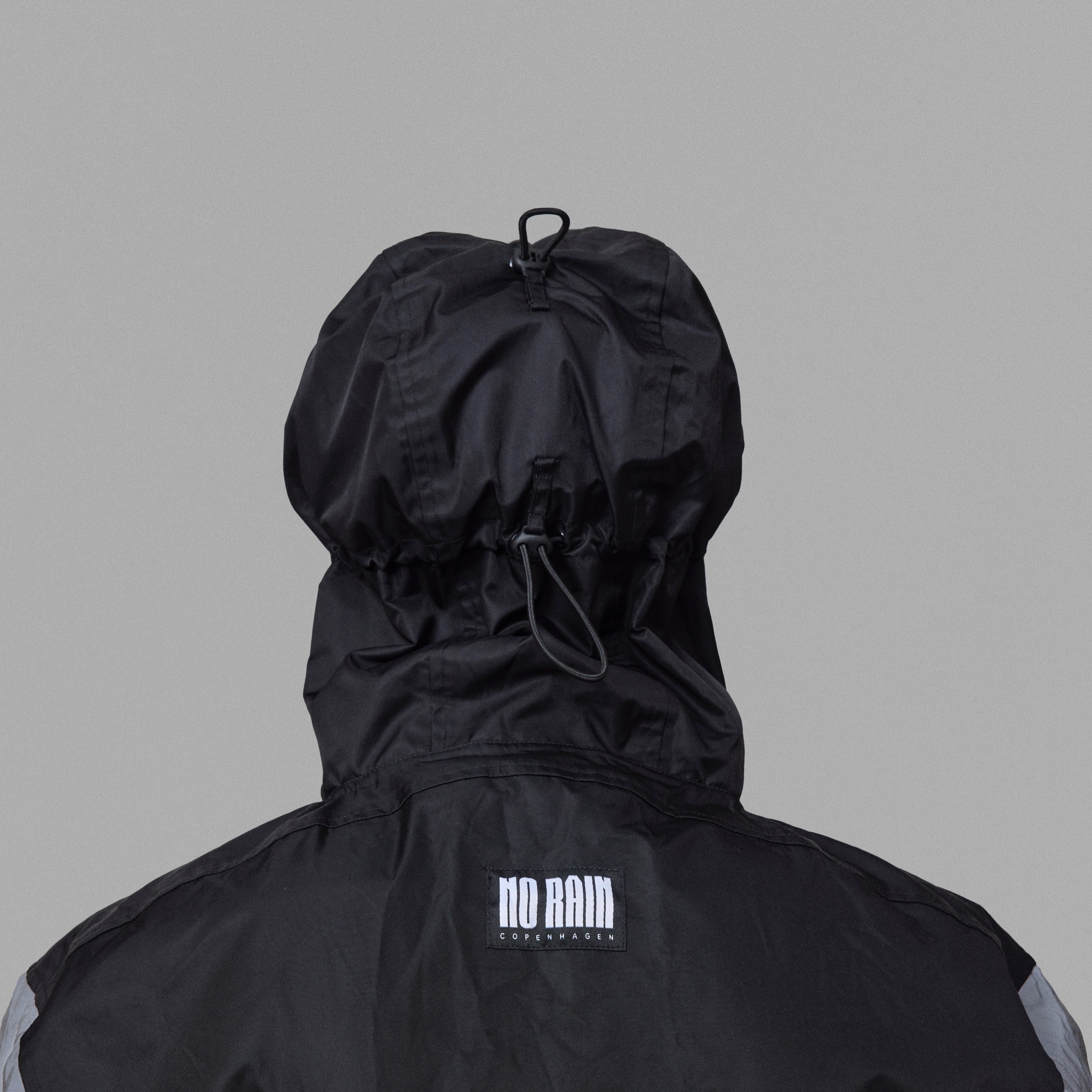 Black NoRain bicycle poncho with a hood on a gray background