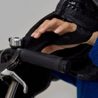 Person wearing a black NoRain Bike poncho holding a bike handlebar with a neutral background