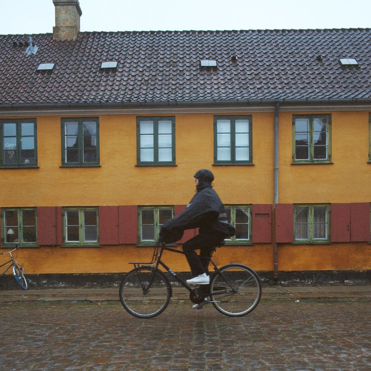 Cyclist wearing a rain poncho while riding a bicycle in the rain