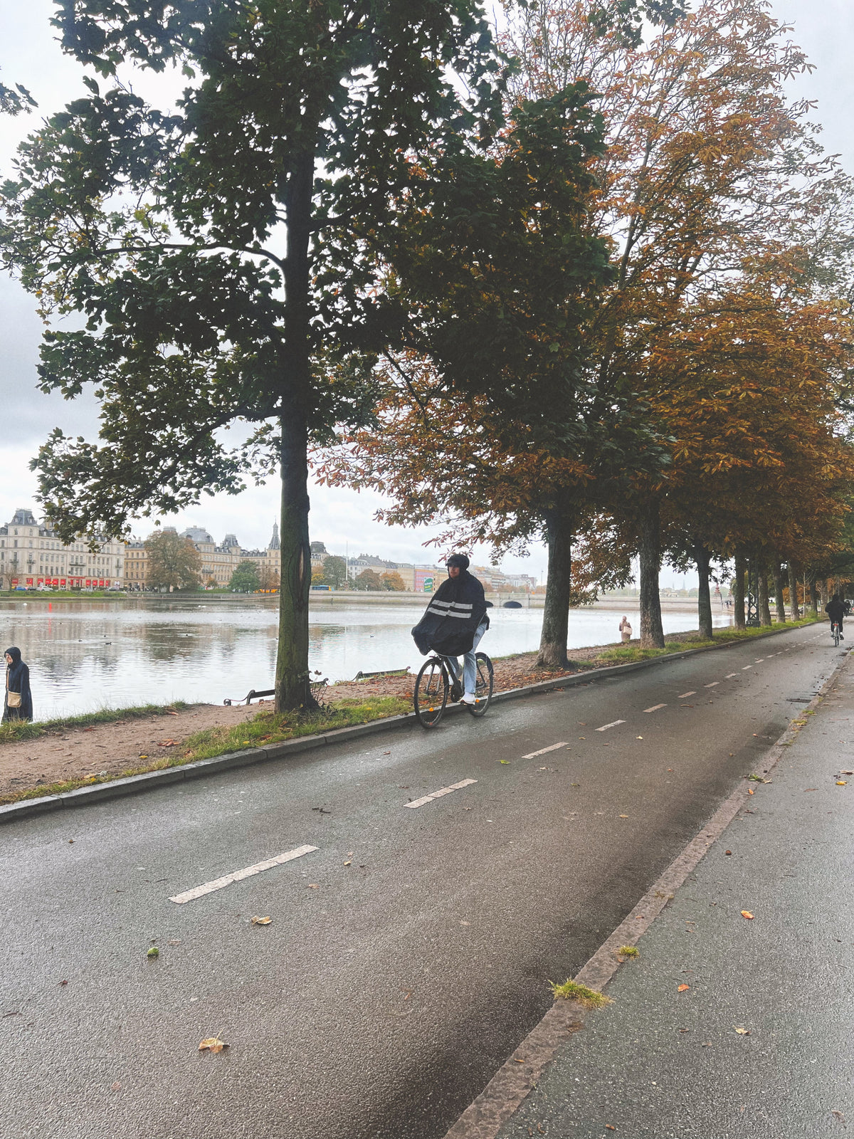 Cyclist commuting to work in the rain wearing waterproof cycling rainwear