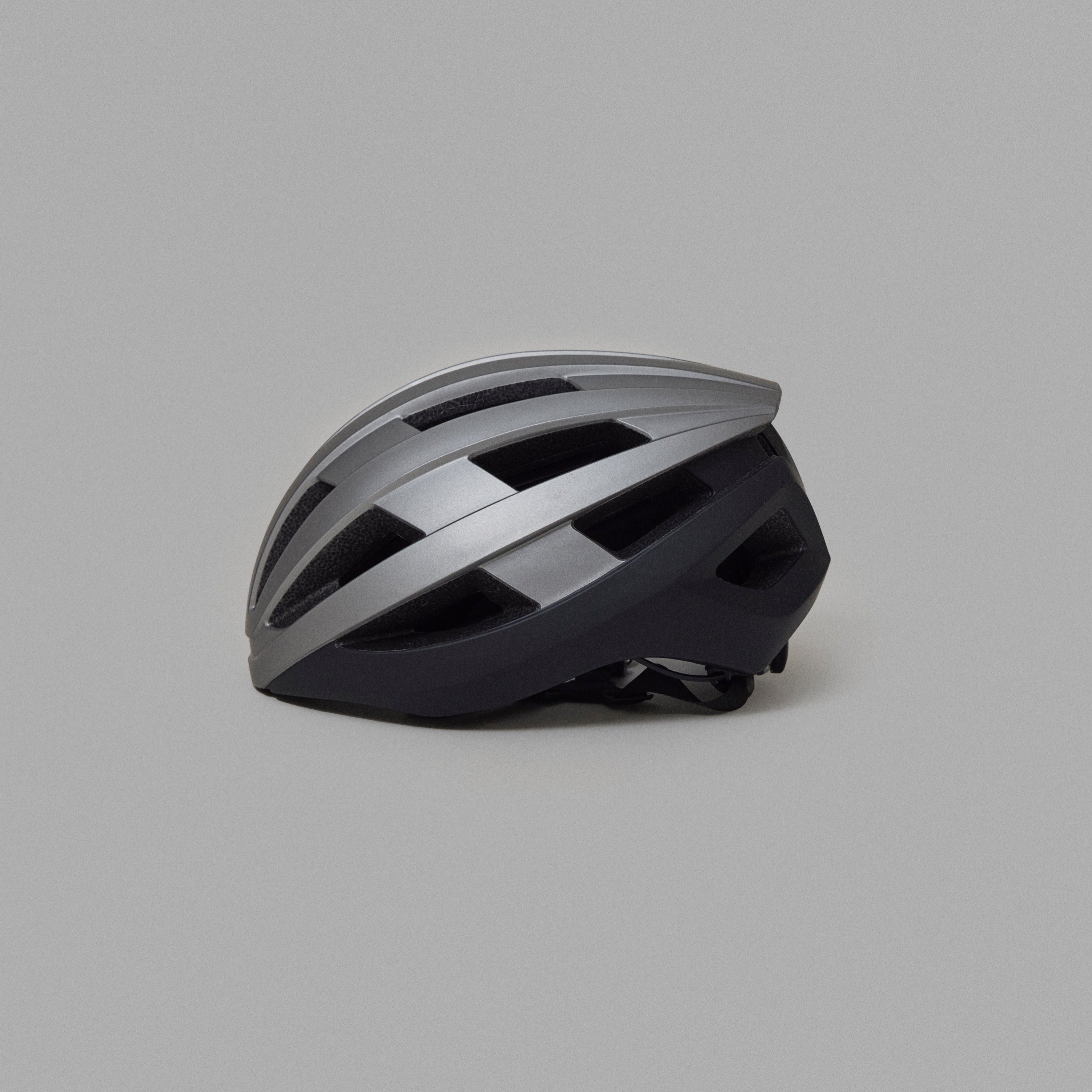 Silver and black NoRain Bicycle helmet on a gray background