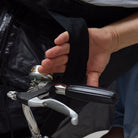 Person holding a bicycle with a black NoRain poncho draped over it