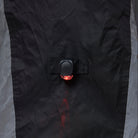Close-up of a black NoRain Bicycle poncho with a button and red light on a gray background