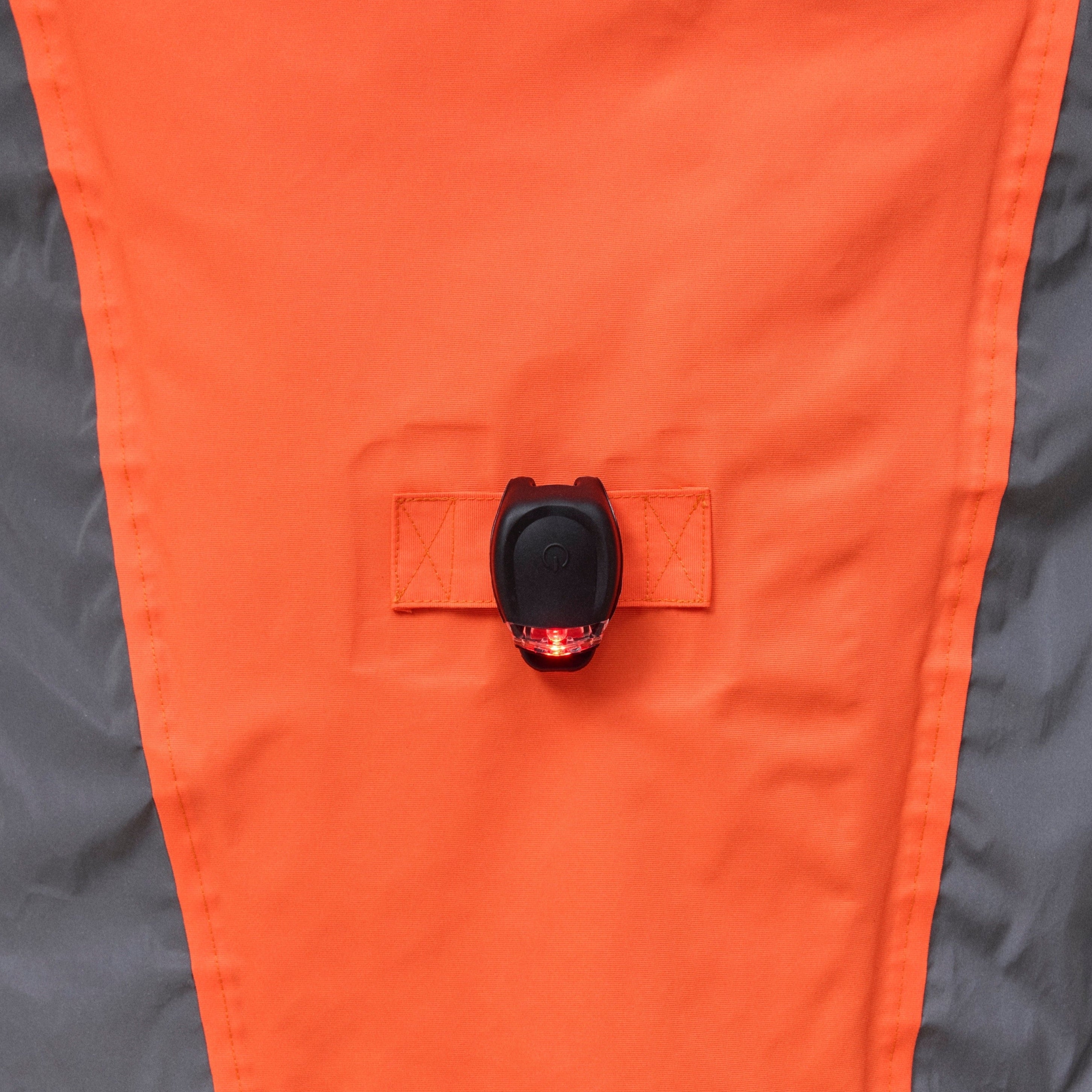 Close-up of an orange and gray NoRain bicycle poncho with a button on a white background
