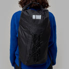 Person wearing a black waterproof Norain  backpack with 'No Rain' logo on a gray background